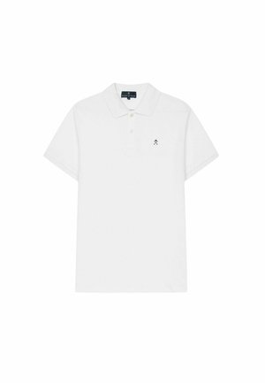 Polo blanco de manga corta con dos botones y pequeño logo negro de palos cruzados en el pecho izquierdo.