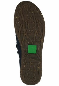 Brown rubber sole featuring textured grip design and a green frog logo embedded in a square. Material shows natural patterns and ridges.