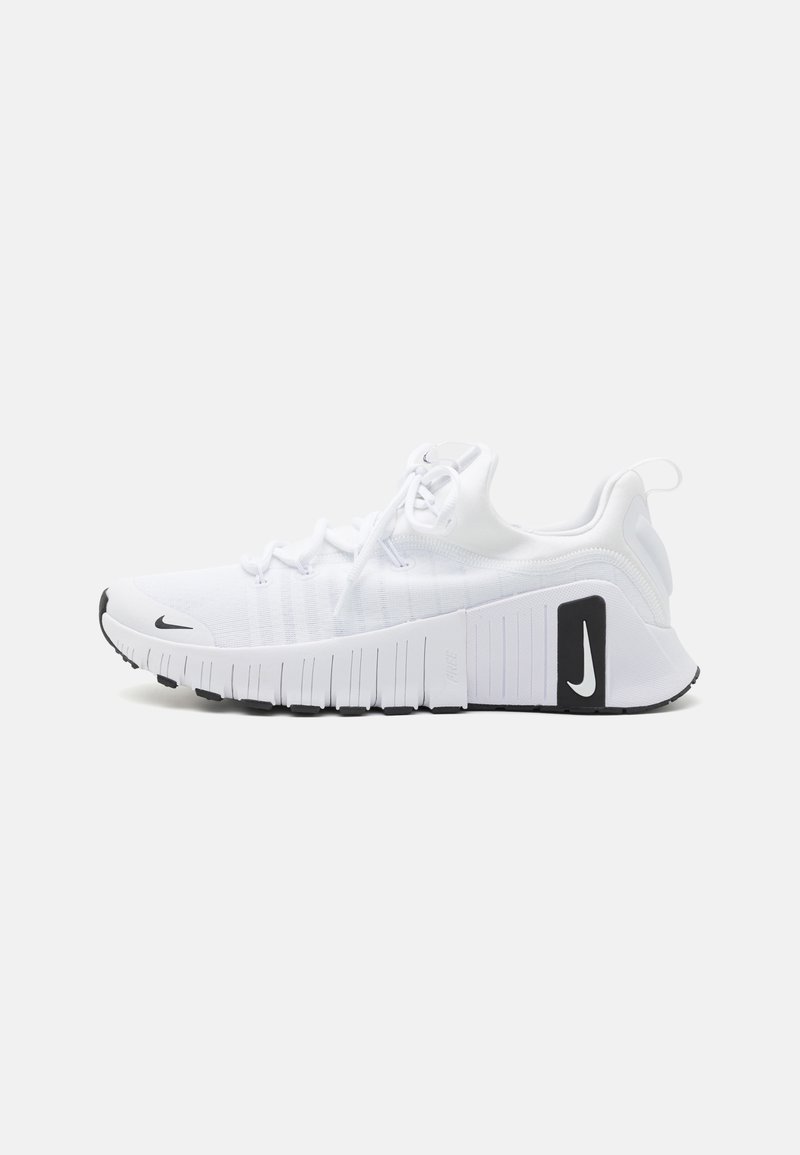 White athletic shoes with a textured fabric upper, flexible sole, and black accents. Features a rounded toe and reinforced heel structure.
