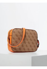 Brun mønstret stofpose med orange læderdetaljer, rektangulær form, justerbar rem og lynlås. Struktureret overflade og kontrastsyninger.