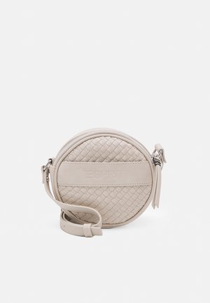 Beżowa okrągła torebka na ramię o plecionej teksturze, z zewnętrznym poziomym paskiem i regulowanym paskiem z klamrą na białym tle.