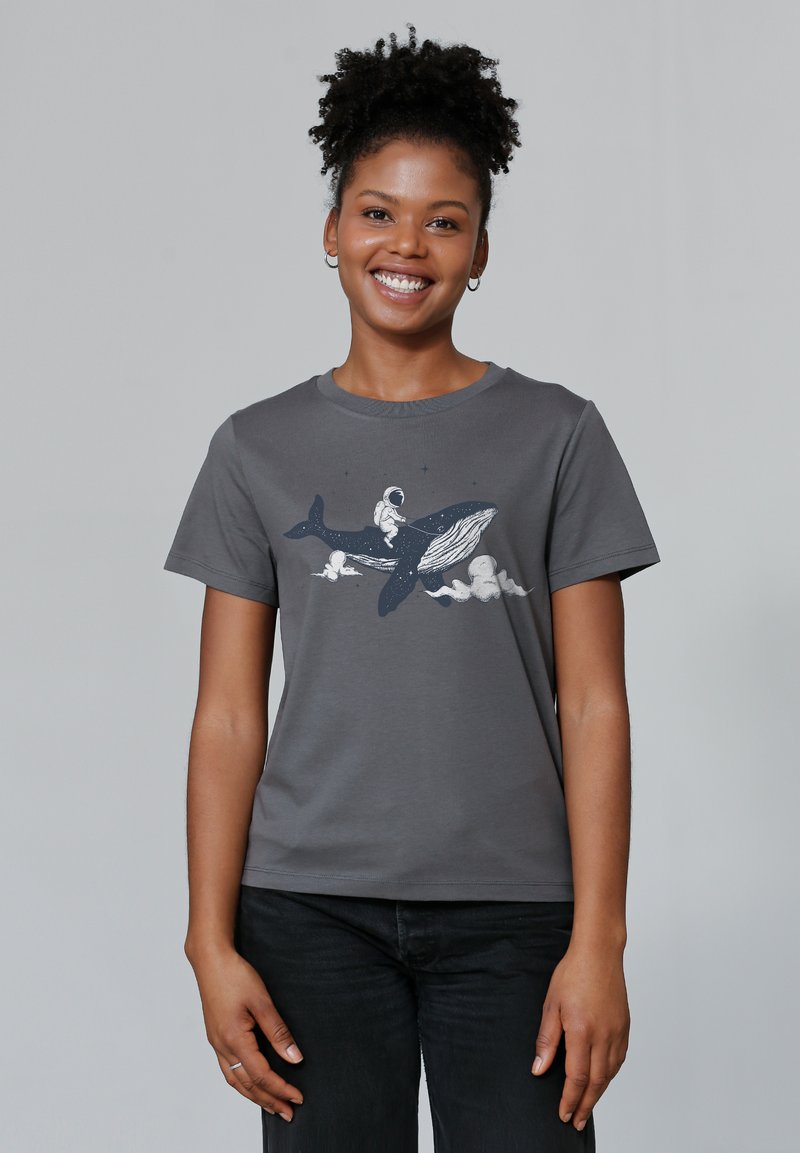 Grijze katoenen t-shirt met een illustratie van een astronaut die op een walvis rijdt in marineblauw en wit, met wolken en sterren op de achtergrond.