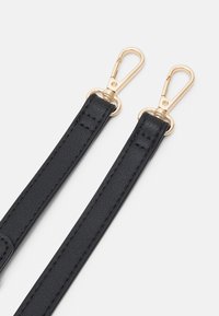 Musta nahkahihna kultasävyisillä metalliklipsuilla, jossa on sileä pinta ja tarkat ompeleet, suunniteltu laukkujen tai asusteiden kiinnittämiseen.