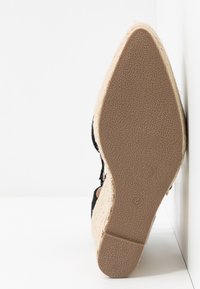 Semelle d'une espadrille compensée pour femme avec semelle en caoutchouc beige texturé et talon en marches, taille marquée 4.