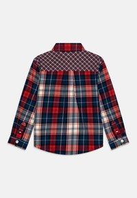 Koszula z długim rękawem, zapinana na guziki, w kratę w kolorach czerwonym, granatowym, białym i szarym, z kontrastowym, mniejszym wzorem w kratę na plecach i mankietach.