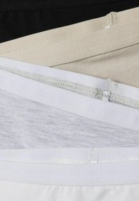 Tre paia di mutande in tessuto elasticizzato impilate: neri, beige e bianchi. Ognuno ha cintura elastica a contrasto e cuciture piatte per il comfort.
