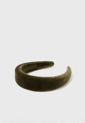 Faixa de veludo em verde oliva escuro. Textura suave com um acabamento liso. Forma arredondada com uma leve curvatura e detalhes costurados no lado interno.