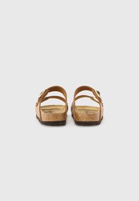 Sandales en cuir marron avec une finition texturée, dotées de deux sangles réglables et d'un semelle intérieure rembourrée. Semelles légères et plates.