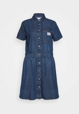 Jeanskleid in Dunkelblau mit kurzen Ärmeln, Knopfleiste vorne und einer aufgesetzten Tasche mit Logo. Rockteil in ausgestelltem Design.