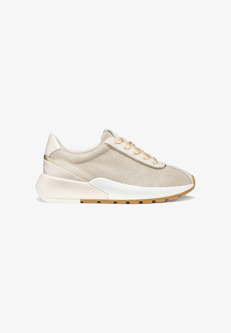 Chaussure de sport beige avec une tige en mesh texturé, des lacets dorés contrastants et une semelle superposée blanche et beige, présentant un design moderne et élégant.