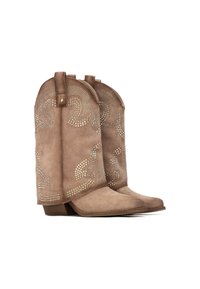 Botas de cowboy de ante de color marrón con tachuelas metálicas decorativas, punta afilada y tacón corto apilado. Presentan un patrón de espiral bordado en el eje.