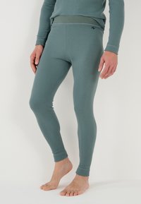 Fitted thermal leggings in muted green, made of soft, stretchy fabric with a smooth texture. Features a comfortable waistband and ankle cuffs.
