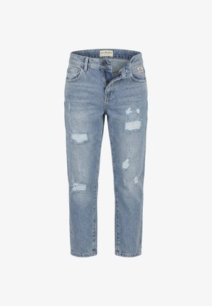 Jeans di denim azzurro chiaro effetto usurato con cerniera frontale parzialmente aperta e numerose toppe sfilacciate sulle gambe.