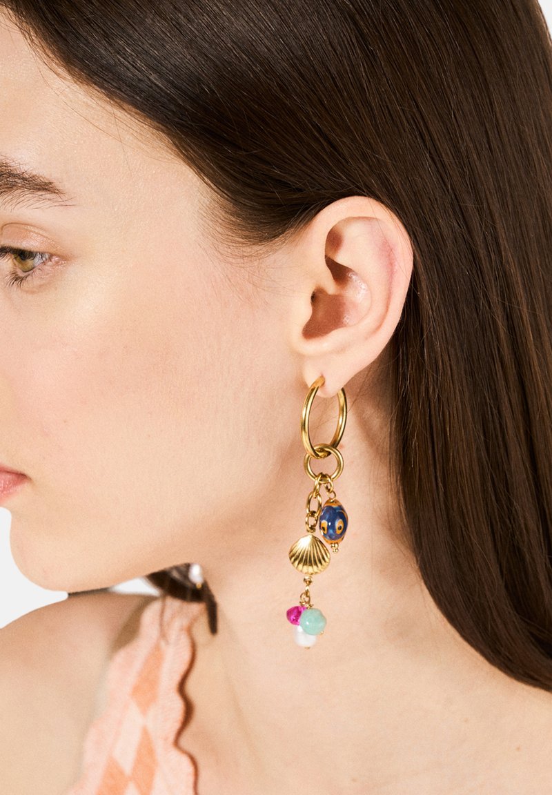 Guldörhänge med en blå pärla, snäcka charm, och flerfärgade pärlor i rosa, turkos och vitt, hängande från en kedja.