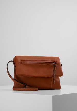 Brown leather crossbody bag with fold-over flap, front zip pocket with studded zipper pull, and adjustable shoulder strap on white surface.