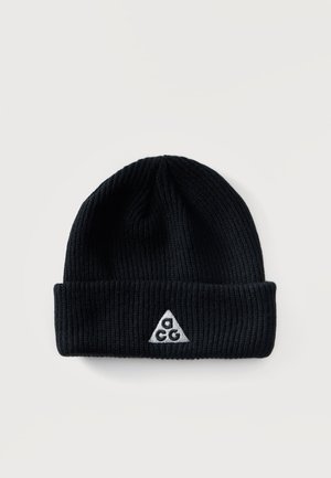 Gorro de punto acanalado negro con puño doblado que presenta un pequeño logo triangular blanco con las letras C A C G en el centro delantero.