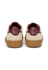 Sneakers met een crèmekleurige textuur bovenkant, maroon leren accenten en een bruine rubberen zool, met een laag profiel ontwerp en een pluche interieur.