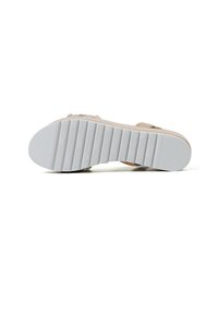 Sandalo beige con tomaia testurizzata, cinturino regolabile e suola in gomma bianca e rigida. La suola offre aderenza e stabilità.