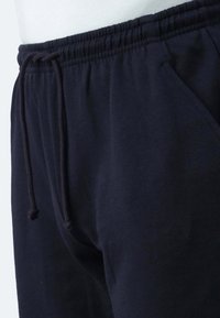 Navy Sweatpants mit einem elastischen Bund, verstellbarem Kordelzug und Seitentaschen. Weicher, leichter Stoff mit glatter Textur.