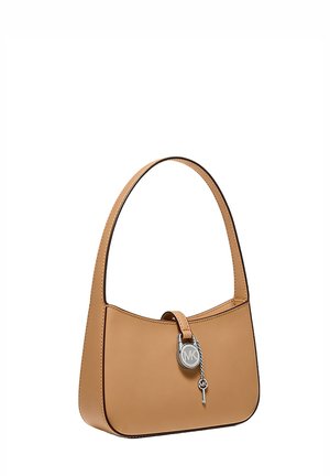 Kleine hellbraune Ledertasche mit einem Trageriemen und silbernem Michael Kors Schloss- und Schlüsselanhänger vorne in der Mitte.