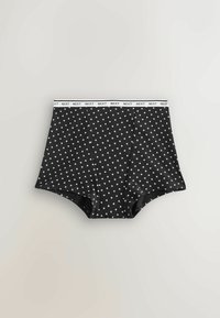 Czarna bawełniana bielizna z białym wzorem serca, z białą elastyczną gumką w pasie oznaczoną napisem „NEXT”. Zaprojektowana w stylu majtek.