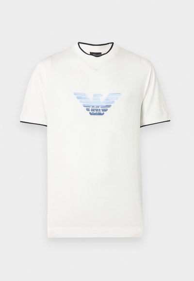 Bijela majica kratkih rukava s plavim gradijentnim logom orla. Crni naglasci na ovratniku i rukavima. Mekani pamuk. Jednostavan dizajn.