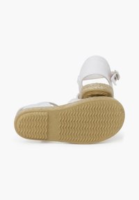Witte sandalen met een geweven bovenwerk van stof en een verstelbare band, voorzien van een gewatteerde rubberen zool met een visgraatpatroon en gegraveerde details.