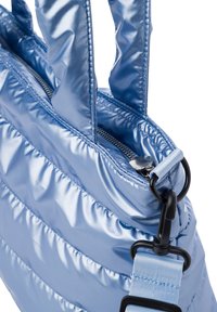 Sac fourre-tout rembourré bleu clair fabriqué en matériau brillant ; dispose de poignées doubles, d'une fermeture éclair et d'une bandoulière ajustable avec un clip.