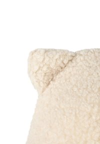 Close-up of a soft, cream-colored textured fabric with a small rounded ear-shaped detail on a white background.