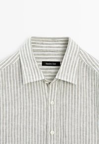 Hellgrau gestreiftes Button-Down-Hemd mit weichem Leinen-Texture, ausgestattet mit einem strukturierten Kragen und perlenähnlichen Knöpfen. Markenlabel: Massimo Dutti.