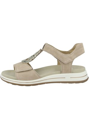 Beige suede sandal with an open toe design, adjustable straps, and a decorative metal accent. Lightweight sole with white and brown detailing.