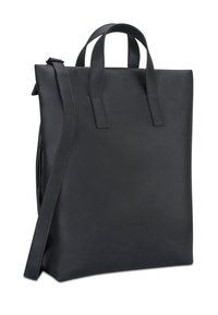 Czarna skórzana torba typu tote o teksturowanej powierzchni, z dwoma górnymi uchwytami i regulowanym paskiem na ramię; minimalistyczny design z nadrukowaną nazwą marki.