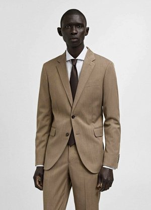 Hellbraunes, strukturiertes Anzug, bestehend aus einer Jacke mit zwei Knöpfen, einer gefalteten Hose, einem weißen Hemd und einer dunkelbraunen Krawatte, mit einer einzelnen Brusttasche.