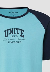Chemise à manches raglan bleu clair et bleu marine avec texte noir « UNITE LET'S Less is more - Less is bore SYNERGIZE » sur le devant.