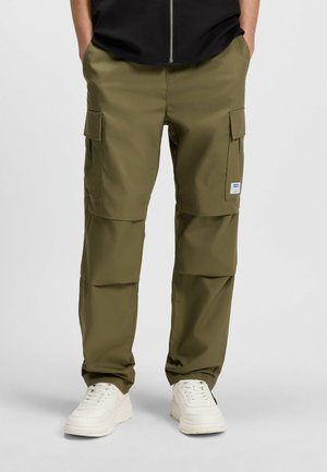 Khaki Cargo-Hosen aus strapazierfähigem Stoff, mit zwei Seitentaschen, einem lockeren Schnitt und einem gerippten Saum, kombiniert mit weißen Sneakers.