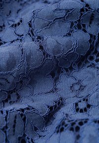 Tela de encaje azul marino con motivos florales, que presenta intrincados detalles troquelados y un fondo texturizado, creando una apariencia en capas.