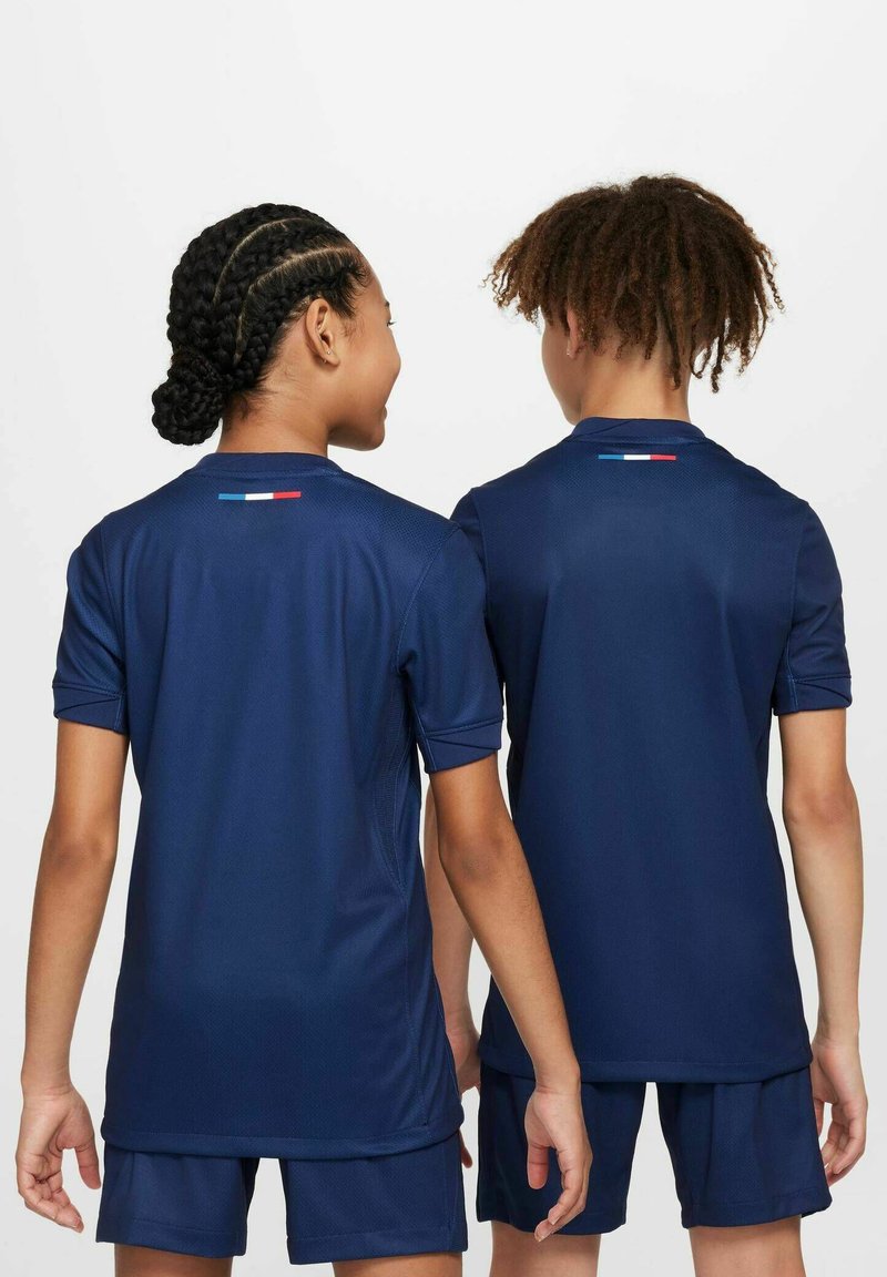 Maillots de sport de marine à manches courtes, avec un tissu texturé et un petit détail tricolore dans le dos. Associés à un short assorti.