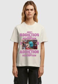 Cream cotton t-shirt featuring bold pink text "JANE'S ADDICTION IMMINENT REDEMPTION" and a central graphic of a crowded event.