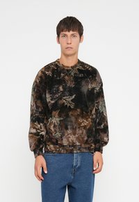 Fluwelen sweatshirt met een camouflagedessin in bruin, groen en zwart. Rondgaande hals, lange mouwen en elastische boorden en onderkant.