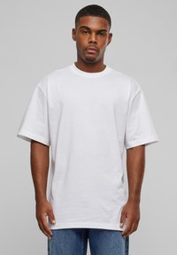 Hvid bomulds t-shirt med rund hals og korte ærmer. Afslappet pasform med en glat tekstur, parret med blå denim jeans.