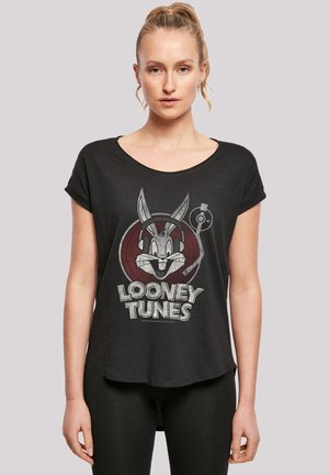 Svart T-skjorte med korte ermer som har et grafisk motiv av Bugs Bunny med hodetelefoner og en vinylplate, trykt i grått og hvitt. Halvavslappet passform.