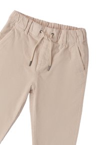 Beige corduroy broek met een gestructureerd oppervlak, elastische tailleband, trekkoord en twee zijzakken.