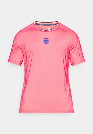 Roosa lühikeste varrukatega T-särk, mis on valmistatud siledast ja kergest kangast. Omab ümmargust kaelust ja sinist embleemi rinnal.