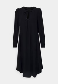 Robe noire à manches longues avec un col rond, un détail de lien au niveau du cou, et une silhouette évasée en ligne A. Tissu doux et lisse sans motifs visibles.