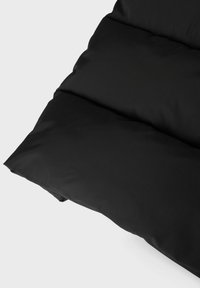 Sort polstret pude med en glat tekstur, vandret syning og en let buet kant, designet til komfort og støtte.