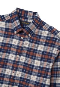 Camicetta a scacchi in navy, marrone e bianco. Colletto button-down con bottoni, tessuto morbido e etichetta con la scritta "PIOMBO."