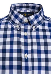 Modrá a bílá kostkovaná košile s límcem na knoflíky, bílými knoflíky a texturovanou bavlněnou tkaninou. Viditelné logo Ralph Lauren.