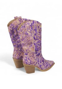 Botas de vaquero moradas y doradas con un patrón ornamentado en espiral, punta afilada y tacón apilado. Superficie texturizada con detalles de costura en contraste.