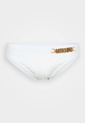 Bela bikini spodnja del z gladko teksturo, z zlatim logotipom "Moschino" na strani in nizkim pasom.