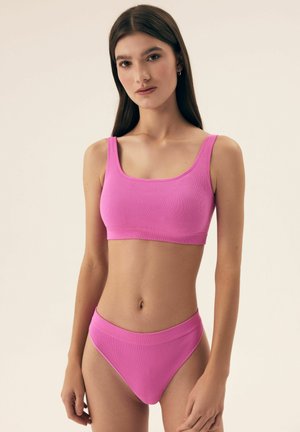 Różowy prążkowany crop top i dopasowane majtki bikini o wysokim stanie. Oba elementy charakteryzują się gładką fakturą oraz szerokimi, wygodnymi paskami.